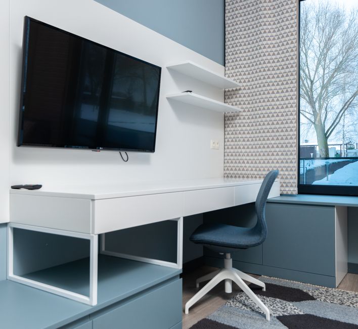 Tienerkamer met bureau, bed en aanpasbare opbergruimte.